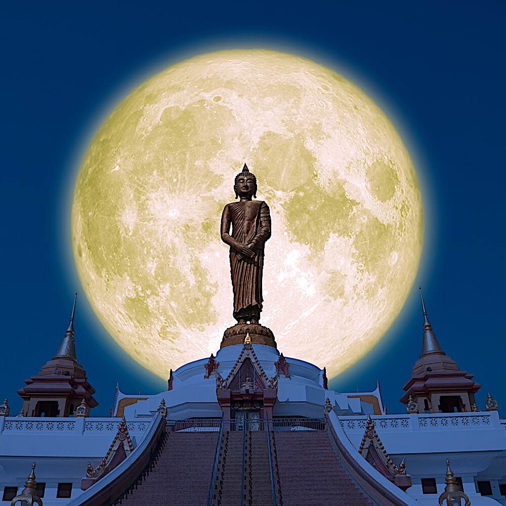 Buddha statue against a full moon.