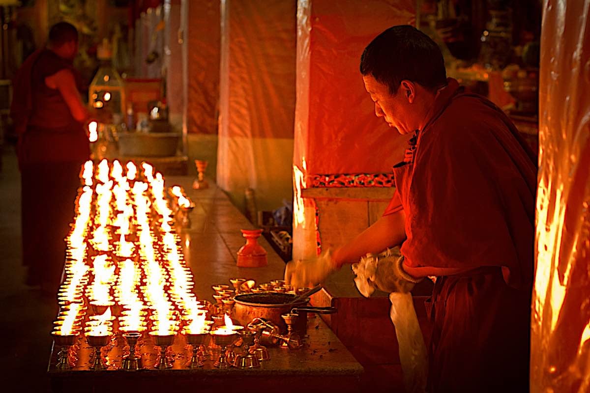 Ganapuja (Gathering Offering) and Ganachakra (Gathering Circle) or Tsog (Tsok): What is it? Why is the Offering Important? When to Celebrate? 4 Buddha Weekly Making offerings on Holy Days Monk lighting candles in Drepung Monastery Lhasa Tibet dreamstime xxl 47678157 Buddhism